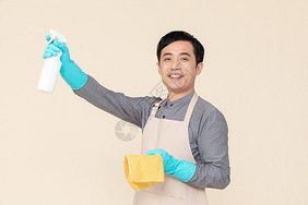 手持喷壶与抹布做清洁的家政服务男性百洁布高清图片素材